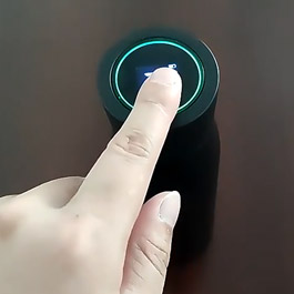Finger pressing the illuminated touch sensor on the Pura UV smart bottle cap