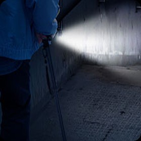 Person using the Ready Walker cane with its LED light switched on in a dark passage