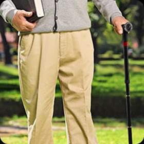 Person standing outdoors holding the Ready Walker folding cane