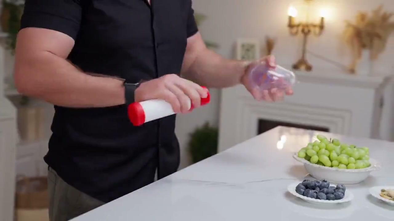 Person holding the ResQVac suction device and a mask in a kitchen