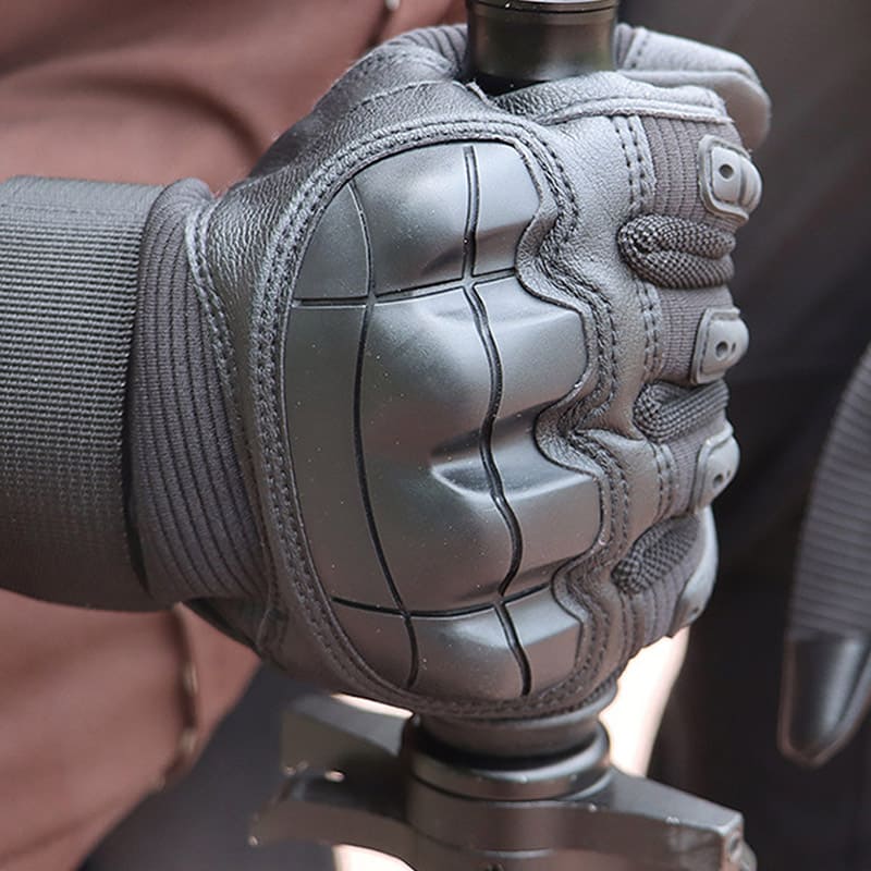 Close-up of the molded hard knuckle guard on a Ruck & Recon style tactical glove gripping a handle