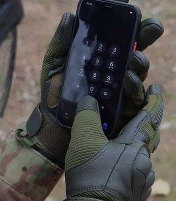 A gloved hand using a smartphone touchscreen, showing the touchscreen fingertips on the Ruck & Recon glove