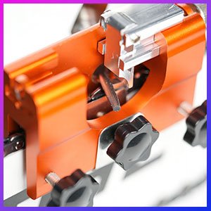 Close-up of the Sherem saw sharpener's carbide grinding wheels on its orange aluminum body