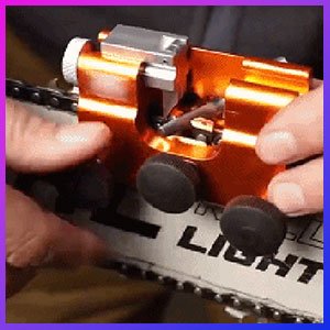 Hands using the Sherem sharpener clamped onto a chainsaw bar to sharpen the chain