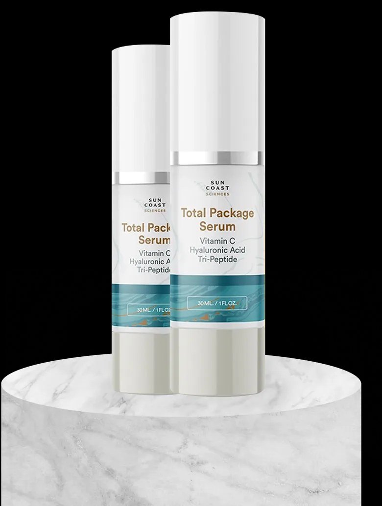 Two Total Package Serum bottles on a marble platform