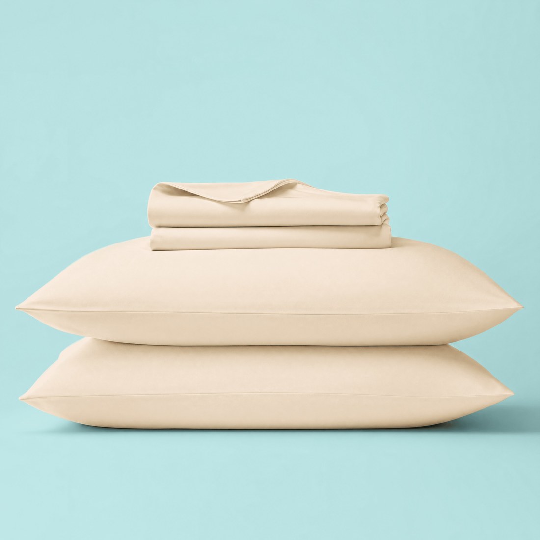 A Sleepgram bamboo sheet set in the oat colorway, stacked with matching pillows