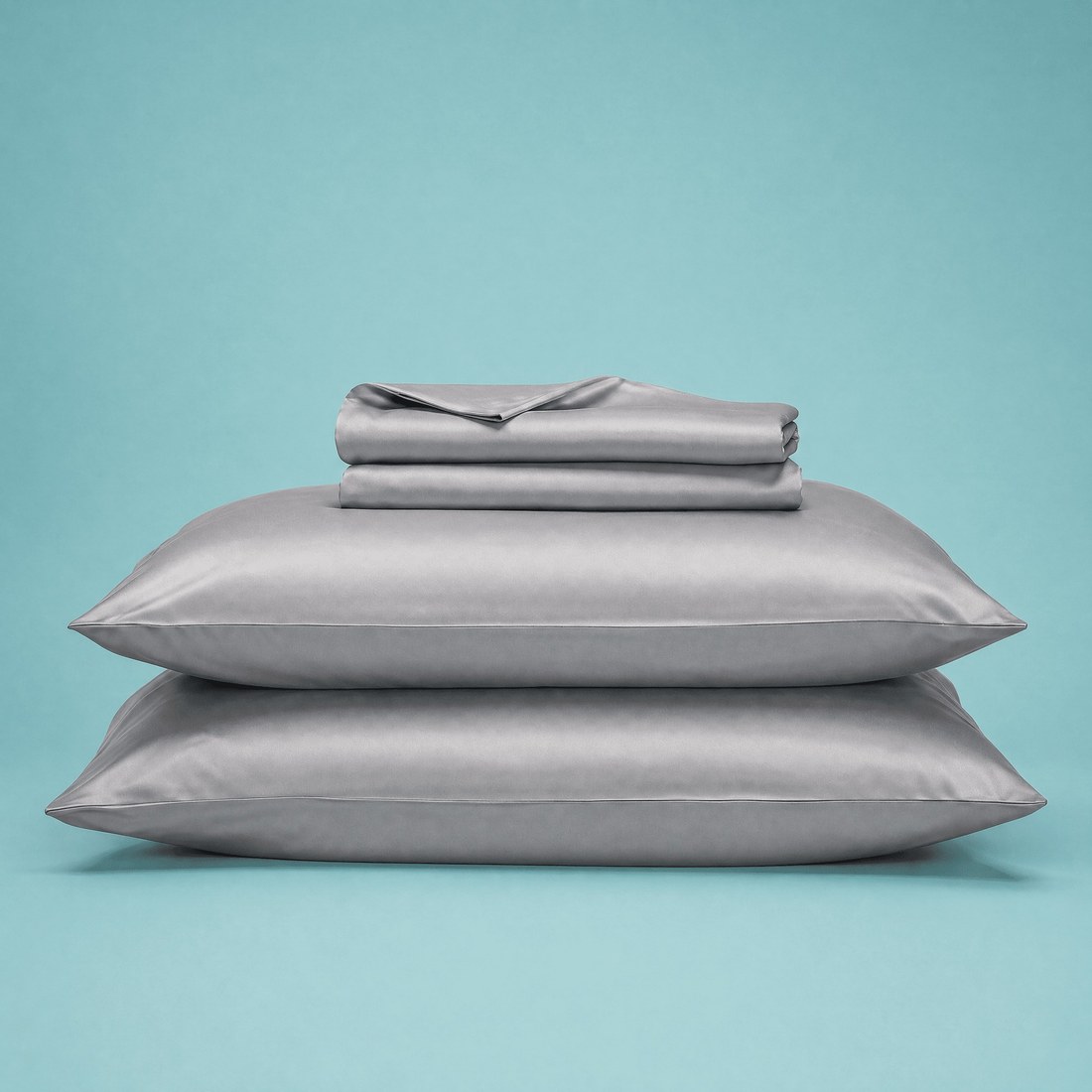 A Sleepgram bamboo sheet set in the slate colorway, stacked with matching pillows