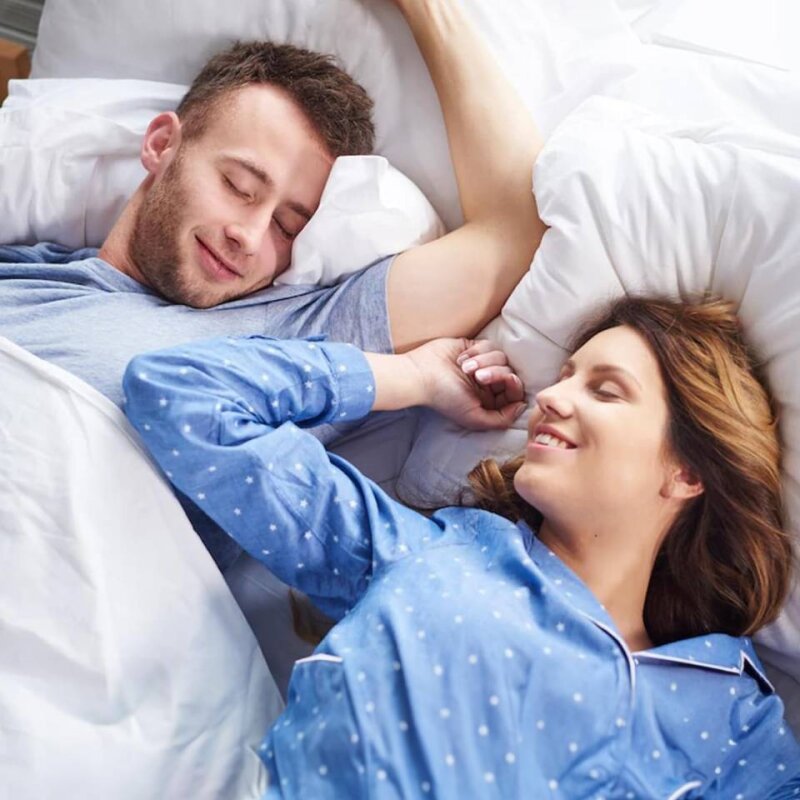 Couple sleeping peacefully in bed after using the SleepZee anti-snoring mouthpiece
