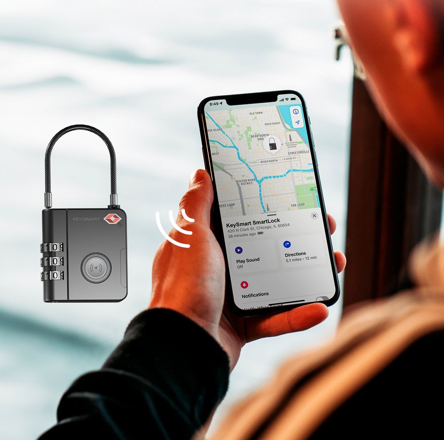 Person holding the SmartLock luggage lock while checking its location in the Apple Find My app on an iPhone