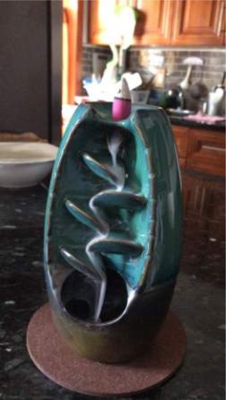 Teal Spirual incense waterfall running on a kitchen counter with smoke flowing down