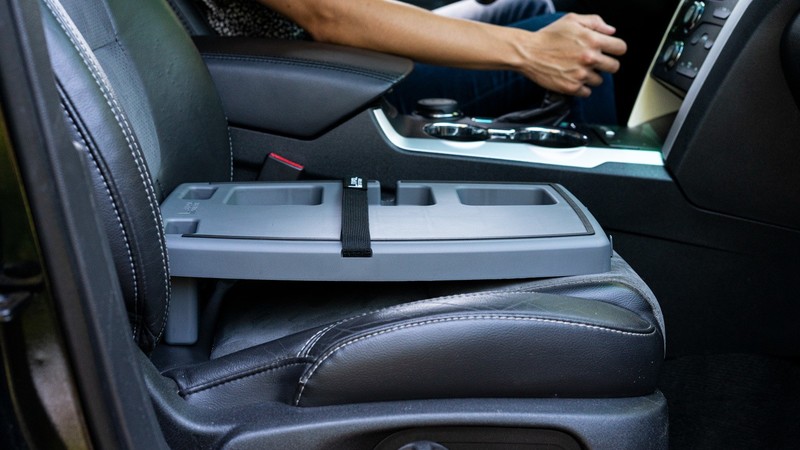 Grey Stupid Car Tray strapped level on a car's front passenger seat