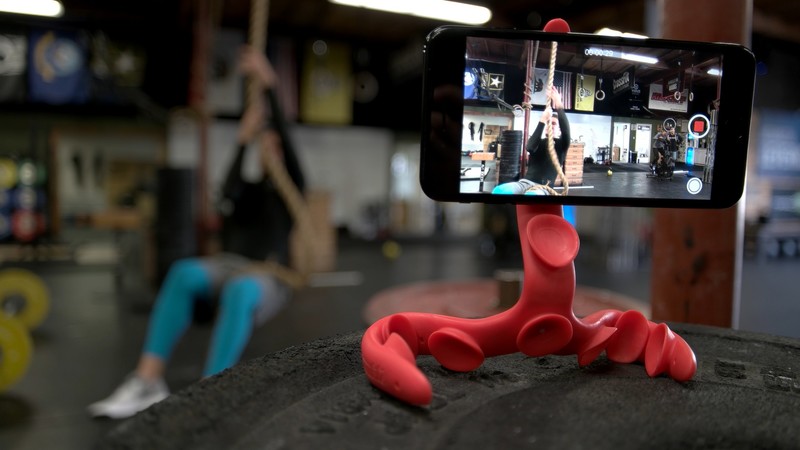 Tenikle flexible mount gripping a gym surface to film a workout on a phone