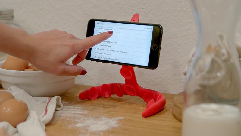 Tenikle flexible mount standing on a kitchen counter, holding a phone that shows a recipe