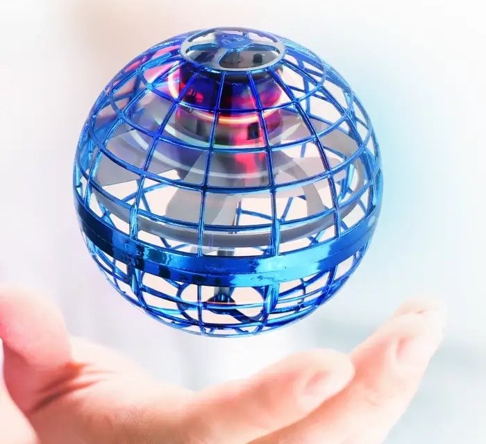 Close-up of the blue caged Orbi Boomerang Ball floating above a hand