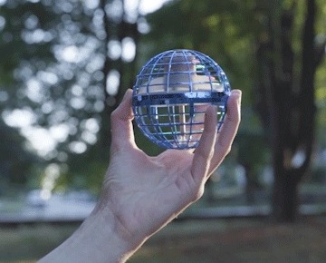The Orbi Boomerang Ball held in an open hand outdoors before launch
