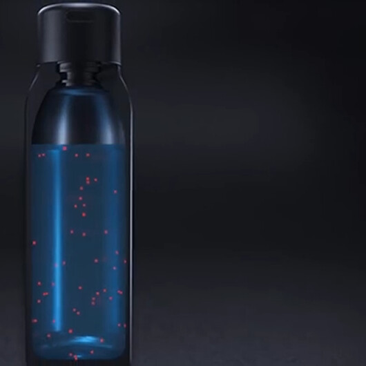 The UVBrite Smart Bottle lit from within during a UV-C cleaning cycle, showing the light reaching the water