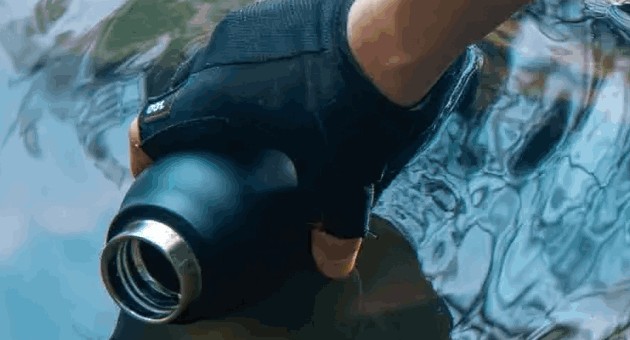 A hand holding the UVBrite Smart Bottle underwater, showing its waterproof build