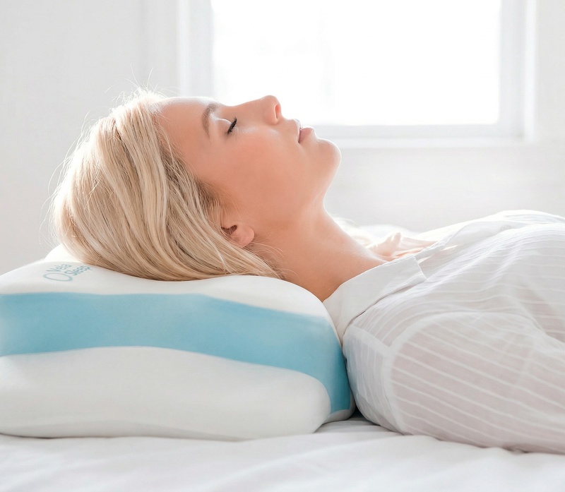 A woman sleeping with her head resting on the VelaSleep contour pillow