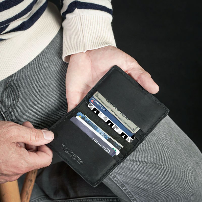 The Wallet Defender card tucked into a leather cardholder alongside credit cards