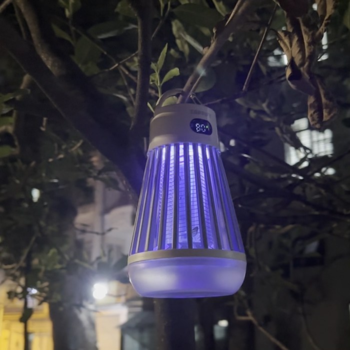 Zappify cordless bug zapper hanging from a tree branch outdoors with its UV light on