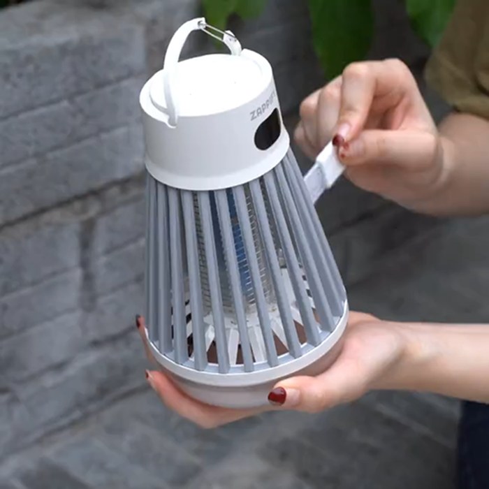 Hands holding the Zappify rechargeable bug zapper and connecting its USB charging cable