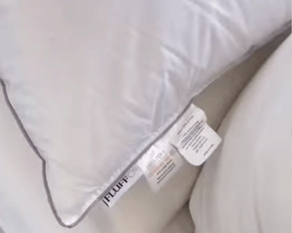 Close-up of the ZenFluffSleep pillow corner showing the piped gusset and Fluffco tag