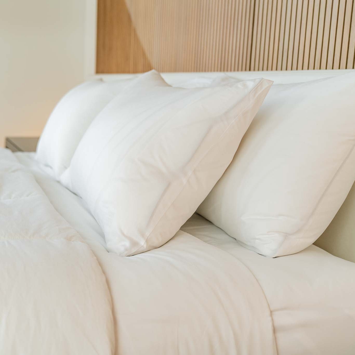 Two ZenFluffSleep pillows propped against the headboard on a neatly made bed