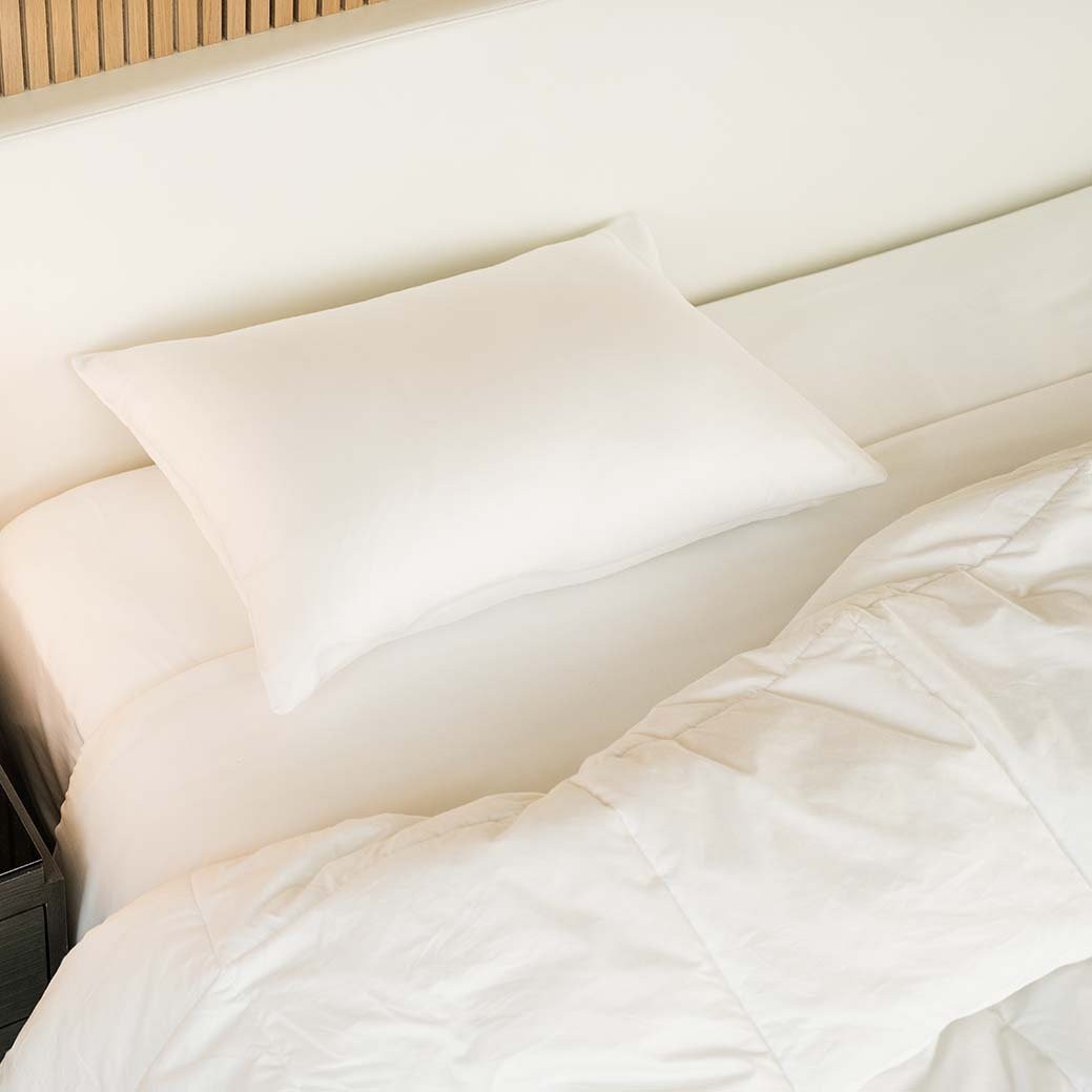 A single ZenFluffSleep down-alternative pillow resting on a made bed