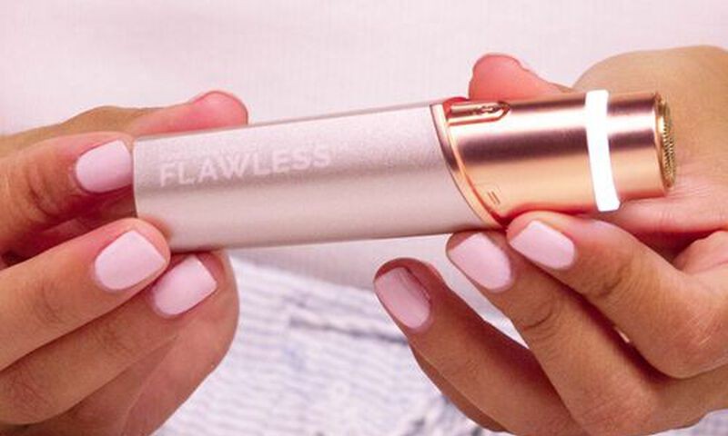 Finishing Touch Flawless facial hair remover held in a woman's hand