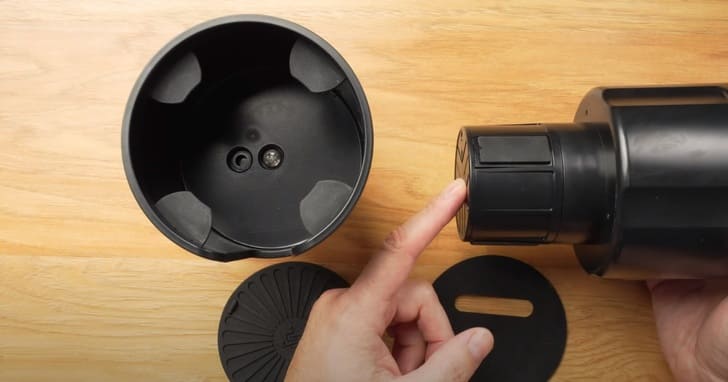 Seven Sparta car cup holder expander shown with its adjustable offset base and coaster on a table
